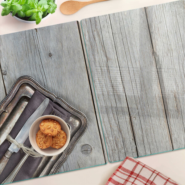 Tagliere in vetro con posate rustiche su sfondo di legno