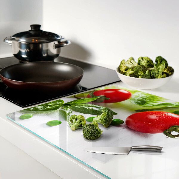 Tagliere in vetro temperato con stampa di verdure su sfondo di piano bianco