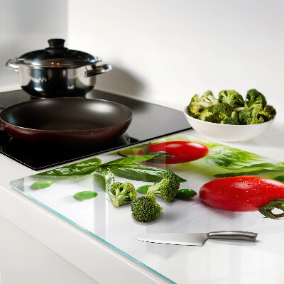 Tagliere in vetro temperato con stampa di verdure su sfondo di piano bianco