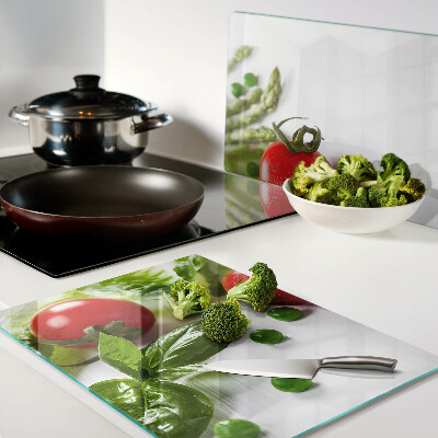 Tagliere in vetro temperato con stampa di verdure su sfondo di piano bianco