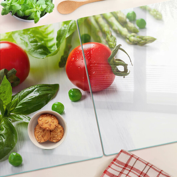 Tagliere in vetro temperato con stampa di verdure su sfondo di piano bianco