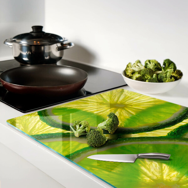 Tagliere in vetro temperato Fette di lime su sfondo verde