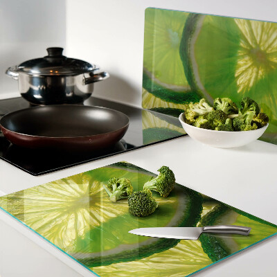 Tagliere in vetro temperato Fette di lime su sfondo verde