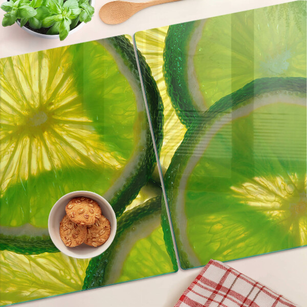 Tagliere in vetro temperato Fette di lime su sfondo verde