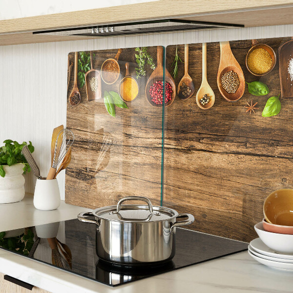 Tagliere in vetro temperato con decorazione di spezie ed erbe su sfondo di legno