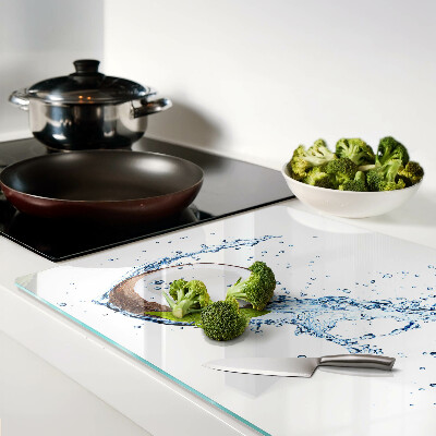 Tagliere in vetro con stampa a tema cocco immerso in acqua con foglie di menta