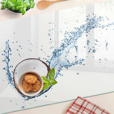 Tagliere in vetro con stampa a tema cocco immerso in acqua con foglie di menta