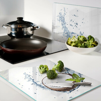 Tagliere in vetro con stampa a tema cocco immerso in acqua con foglie di menta