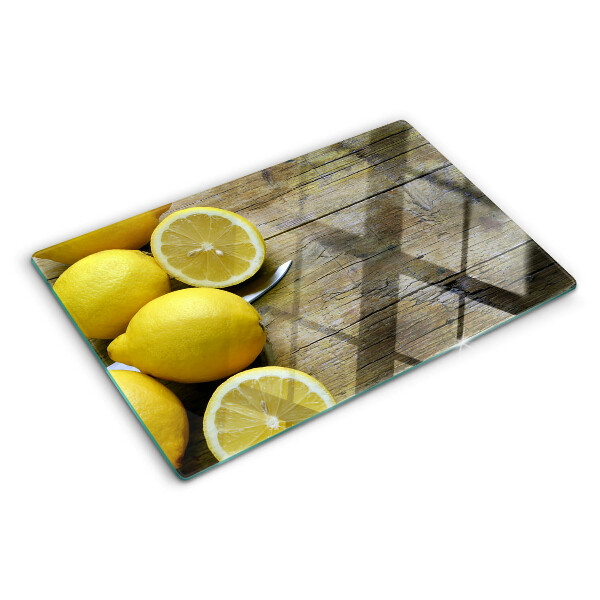 Tagliere in vetro con stampa di limoni su sfondo di legno