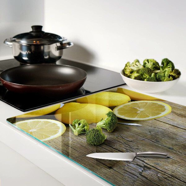 Tagliere in vetro con stampa di limoni su sfondo di legno