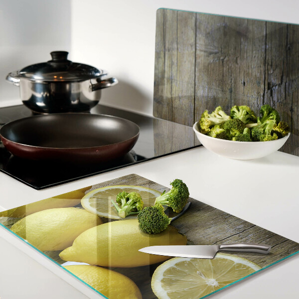 Tagliere in vetro con stampa di limoni su sfondo di legno