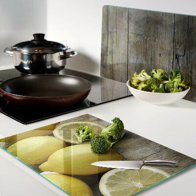 Tagliere in vetro con stampa di limoni su sfondo di legno