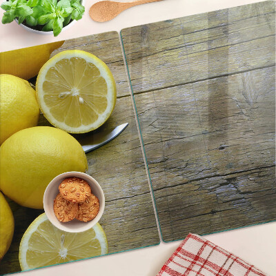 Tagliere in vetro con stampa di limoni su sfondo di legno