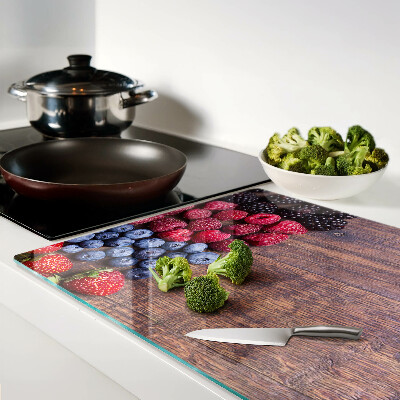 Tagliere in vetro temperato con stampa di frutti di bosco su sfondo di legno