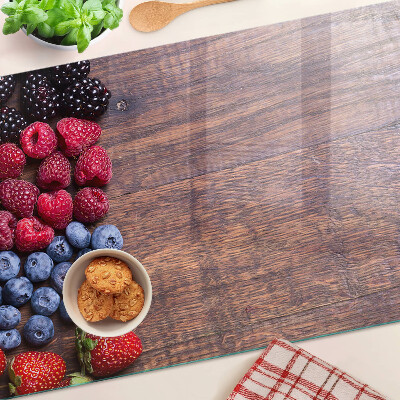 Tagliere in vetro temperato con stampa di frutti di bosco su sfondo di legno