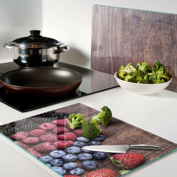 Tagliere in vetro temperato con stampa di frutti di bosco su sfondo di legno