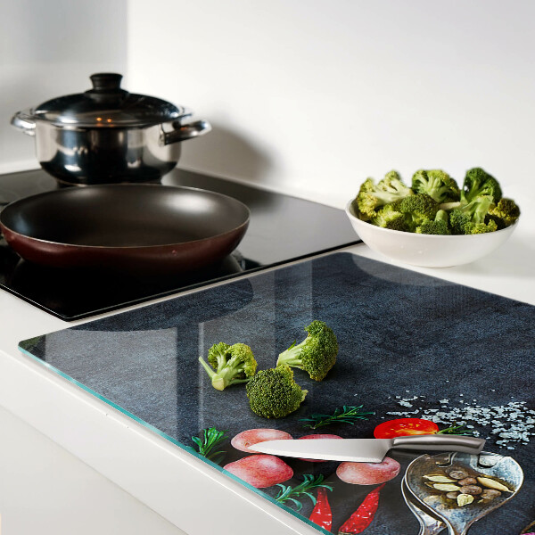 Tagliere in vetro temperato con stampa di verdure e spezie su sfondo scuro