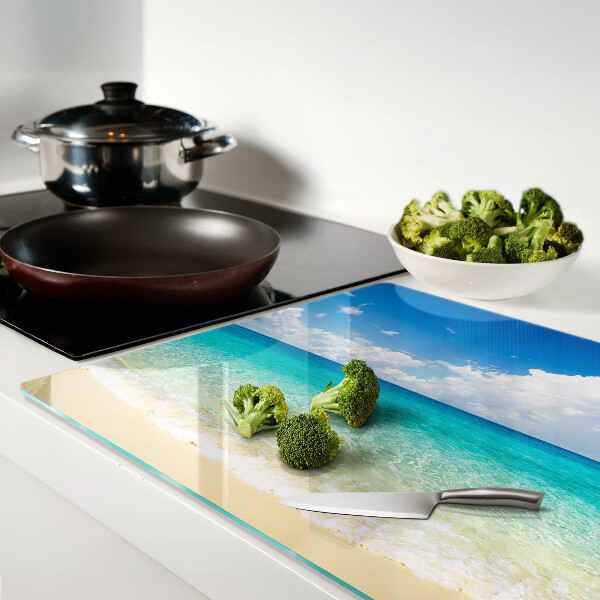 Tagliere in vetro con stampa di una spiaggia con acqua turchese e nuvole