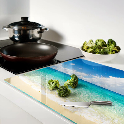 Tagliere in vetro con stampa di una spiaggia con acqua turchese e nuvole