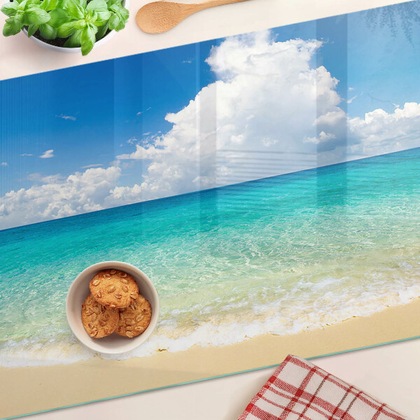 Tagliere in vetro con stampa di una spiaggia con acqua turchese e nuvole