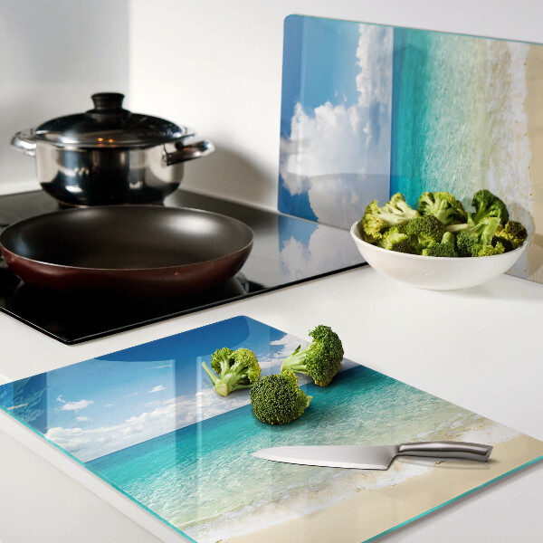 Tagliere in vetro con stampa di una spiaggia con acqua turchese e nuvole