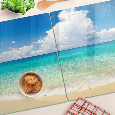Tagliere in vetro con stampa di una spiaggia con acqua turchese e nuvole
