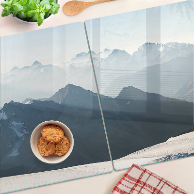 Tagliere in vetro con stampa di un paesaggio montano tra le nuvole