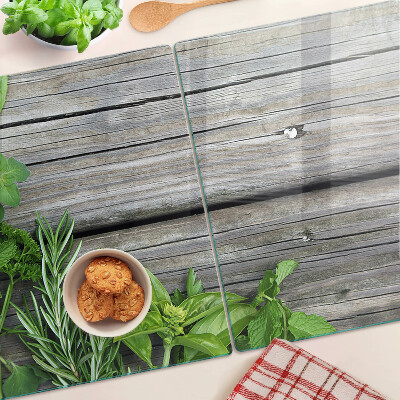 Tagliere in vetro temperato con motivo di erbe verdi su sfondo in legno