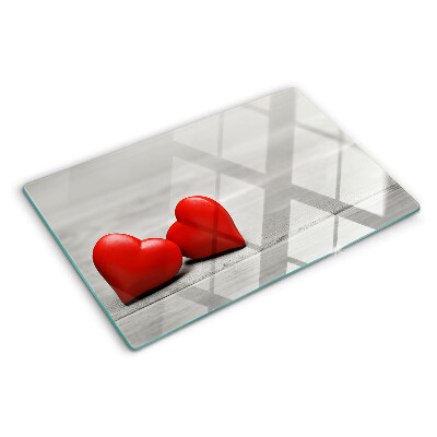 Tagliere in vetro con motivo di cuori rossi su sfondo di legno