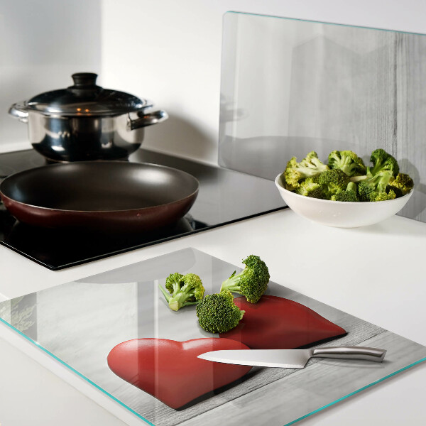 Tagliere in vetro con motivo di cuori rossi su sfondo di legno