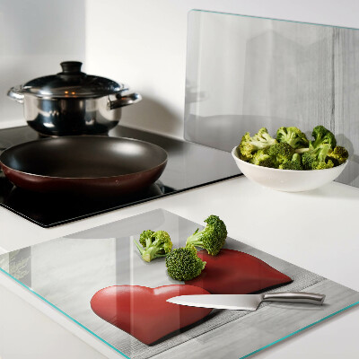 Tagliere in vetro con motivo di cuori rossi su sfondo di legno