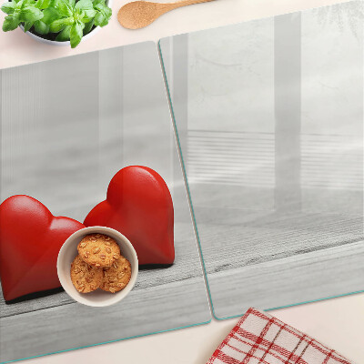 Tagliere in vetro con motivo di cuori rossi su sfondo di legno
