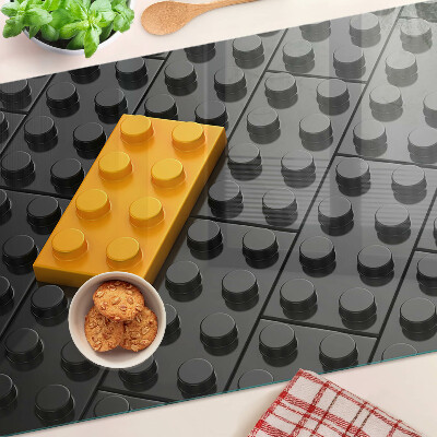 Tagliere in vetro con stampa di mattoncini LEGO su sfondo nero
