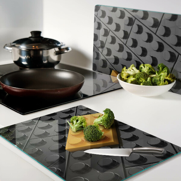 Tagliere in vetro con stampa di mattoncini LEGO su sfondo nero