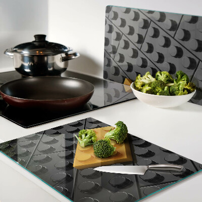 Tagliere in vetro con stampa di mattoncini LEGO su sfondo nero