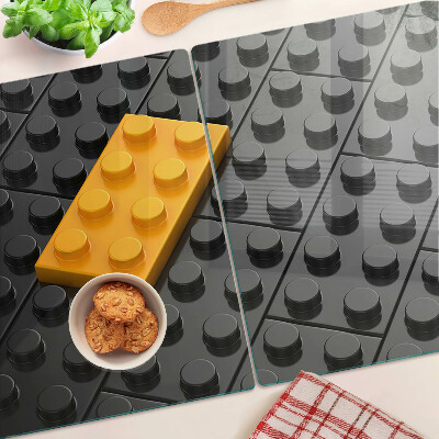 Tagliere in vetro con stampa di mattoncini LEGO su sfondo nero