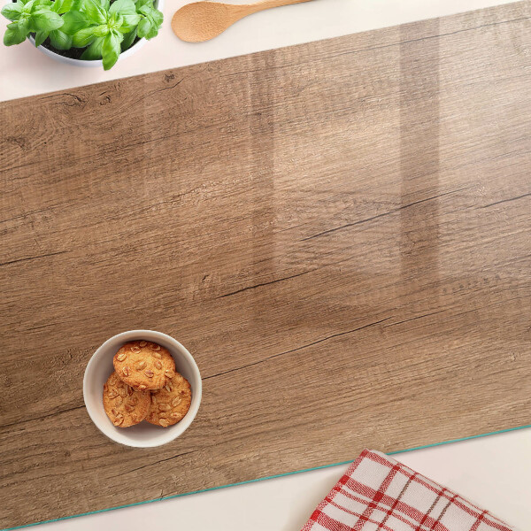 Tagliere in vetro con motivo a venature di legno che riflette la luce della finestra