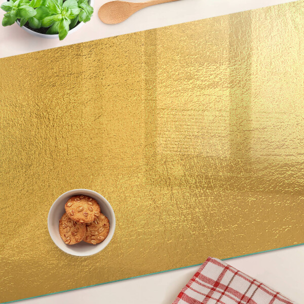Tagliere in vetro temperato con superficie dorata dai riflessi luminosi