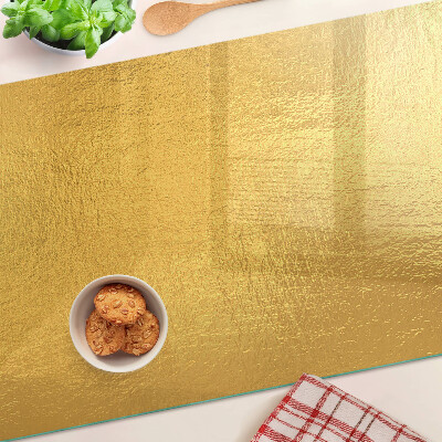 Tagliere in vetro temperato con superficie dorata dai riflessi luminosi