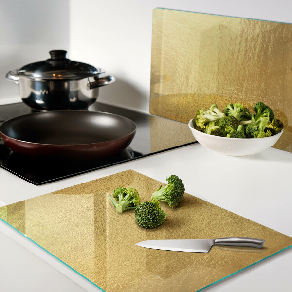 Tagliere in vetro temperato con superficie dorata dai riflessi luminosi