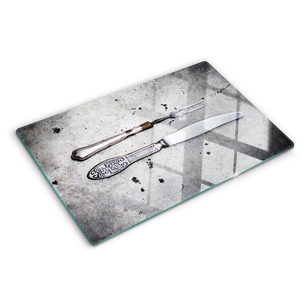 Tagliere in vetro temperato con motivo di posate su sfondo effetto cemento