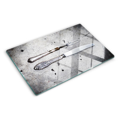 Tagliere in vetro temperato con motivo di posate su sfondo effetto cemento