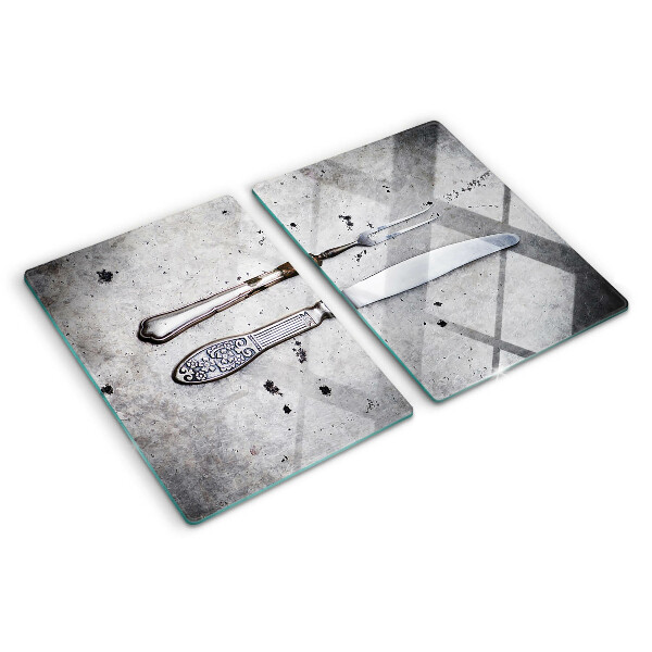 Tagliere in vetro temperato con motivo di posate su sfondo effetto cemento