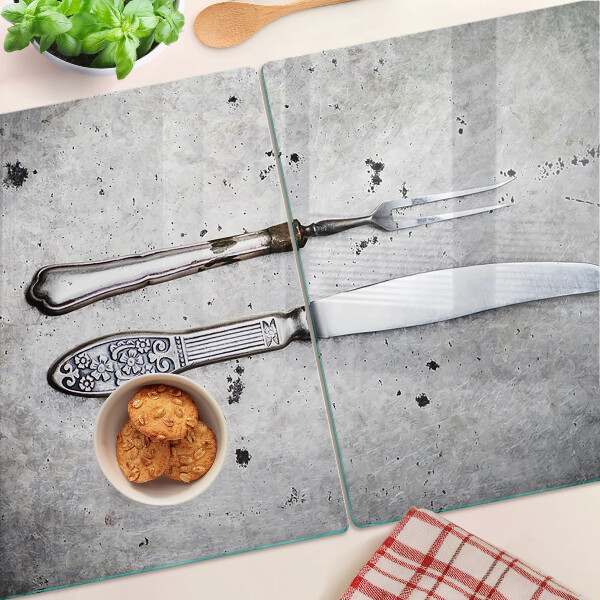 Tagliere in vetro temperato con motivo di posate su sfondo effetto cemento