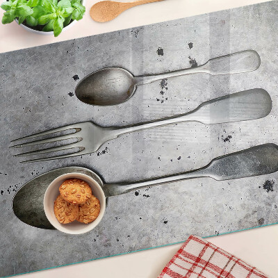 Tagliere in vetro temperato con motivo di posate su sfondo effetto cemento