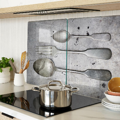 Tagliere in vetro temperato con motivo di posate su sfondo effetto cemento