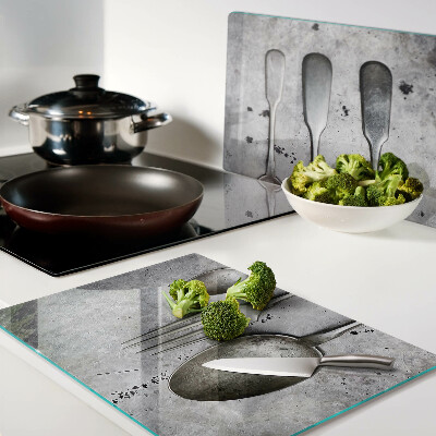 Tagliere in vetro temperato con motivo di posate su sfondo effetto cemento