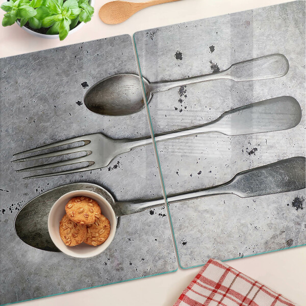 Tagliere in vetro temperato con motivo di posate su sfondo effetto cemento