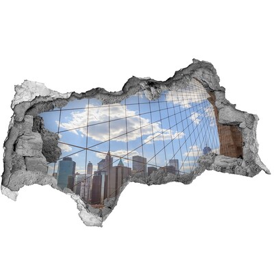 Sticker effetto rottura muro Vista della città attraverso un buco nel muro