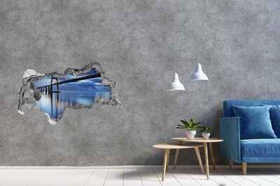 Adesivo con vista dietro il muro Un ponte sull'acqua in una scena notturna